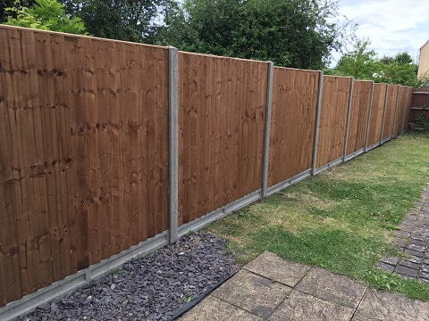Close board panel fence, with concrete posts and gravel boards.