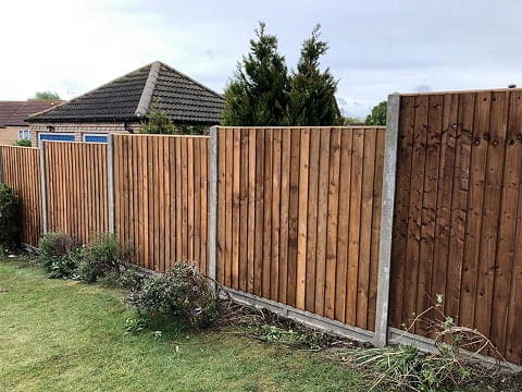Close board panel fence, with concrete posts and gravel boards.